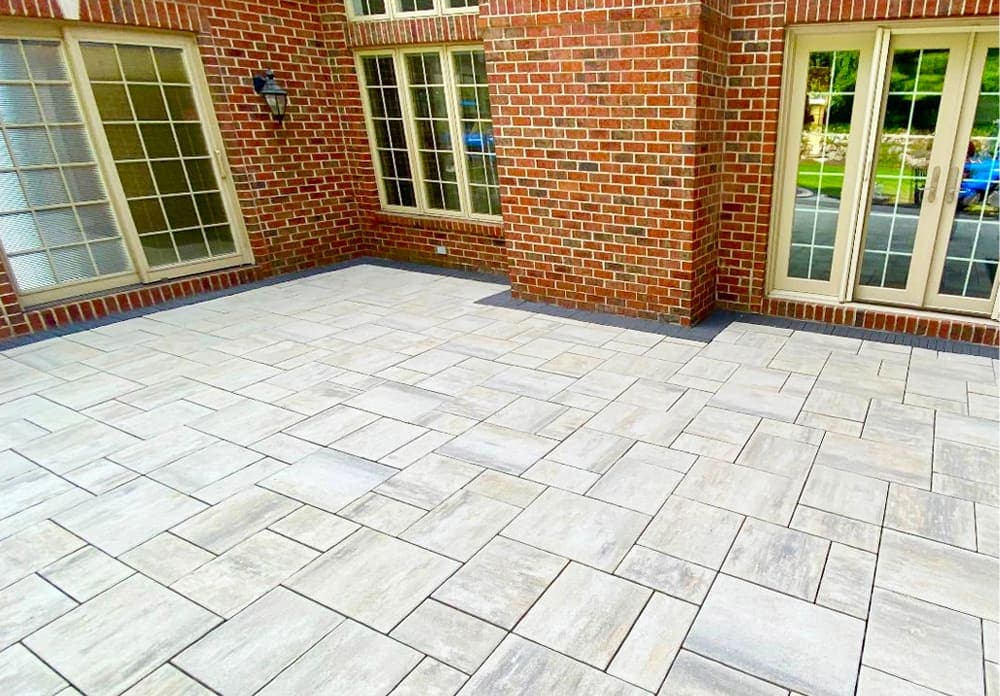 Modern brick home patio with stylish gray stone pavers and large windows for natural light.